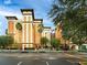 Exterior view of a multi-story resort building with palm trees and well-maintained landscaping at 12527 Floridays Resort Dr # 401E, Orlando, FL 32821