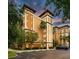 Beautiful exterior shot of a condo building featuring manicured landscaping and a parking lot at 12527 Floridays Resort Dr # 401E, Orlando, FL 32821