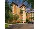 Attractive exterior view with lush landscaping, palm trees, and ample parking at 12527 Floridays Resort Dr # 401E, Orlando, FL 32821