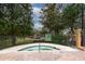 Inviting hot tub surrounded by lush landscaping and a wrought-iron fence at 12527 Floridays Resort Dr # 401E, Orlando, FL 32821