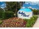FloridaDays Resort sign in Orlando boasts colorful flowers and manicured landscaping against a blue sky at 12527 Floridays Resort Dr # 401E, Orlando, FL 32821