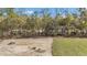Backyard with green grass that meets a clearing surrounded by thick trees at 12639 Sw 78Th Pl, Dunnellon, FL 34432
