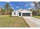 Charming one-story home with a well-manicured lawn and a two-car garage on a sunny day at 12639 Sw 78Th Pl, Dunnellon, FL 34432