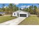 Attractive one-story home with a white exterior, two-car garage, and pristine lawn at 12639 Sw 78Th Pl, Dunnellon, FL 34432