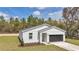 Inviting home featuring white siding, an attached garage, and a neatly landscaped front yard with green grass at 12639 Sw 78Th Pl, Dunnellon, FL 34432