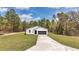 Beautiful white home with a long driveway leading to an attached two-car garage and lush green lawn at 12639 Sw 78Th Pl, Dunnellon, FL 34432
