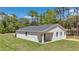 Rear exterior view showcases a well-maintained lawn, and pristine white walls at 13274 Sw 82Nd Ln, Dunnellon, FL 34432