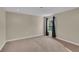 This carpeted bedroom features neutral walls and trim and a window with curtains at 1420 Prairie Oaks Dr, St Cloud, FL 34771