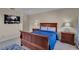 This carpeted bedroom features a queen bed, bedside tables, and a large wall-mounted television at 1420 Prairie Oaks Dr, St Cloud, FL 34771