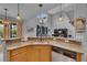 Open kitchen layout with stainless steel sink, hardwood cabinets, granite countertops, and bar seating at 1420 Prairie Oaks Dr, St Cloud, FL 34771