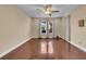 An empty sun-filled living room features beautiful hard wood floors and several windows for ample natural light at 1420 Prairie Oaks Dr, St Cloud, FL 34771
