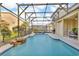 Backyard pool features screened-in enclosure, waterfall feature, and dining set at 1420 Prairie Oaks Dr, St Cloud, FL 34771