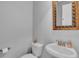 A half bathroom featuring a toilet and small sink with an ornate gold framed mirror above at 1420 Prairie Oaks Dr, St Cloud, FL 34771
