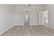 Bright bedroom with wood-look flooring, white walls, and a glimpse of the kitchen through the open doorway at 17052 Sw 44Th Cir, Ocala, FL 34473