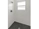Modern shower with black honeycomb floor and white marble walls at 17052 Sw 44Th Cir, Ocala, FL 34473
