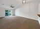 Spacious living room with vaulted ceiling, ceiling fan, and sliding door to the patio at 1817 Christina Lee Ln, St Cloud, FL 34769