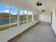 Enclosed patio with large windows offering scenic lake views and ceiling fans at 1817 Christina Lee Ln, St Cloud, FL 34769