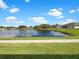 Scenic pond view with green grass surrounding a home on a sunny day under a blue sky at 1817 Christina Lee Ln, St Cloud, FL 34769