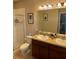 Elegant bathroom featuring double sinks, granite countertops, and a glass-enclosed shower at 1828 Lemon Drop Ct, Apopka, FL 32712