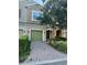 Inviting townhouse with arched entry and landscaped front, enhanced by a brick driveway at 1828 Lemon Drop Ct, Apopka, FL 32712