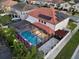 Aerial view of a home with a screened-in pool area, with landscape lighting and a terracotta tile roof at 19313 Pummelo Dr, Orlando, FL 32827