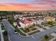 Stunning sunset view of a neighborhood showcasing a home with solar panels and a terracotta tile roof at 19313 Pummelo Dr, Orlando, FL 32827