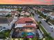 Aerial view of a house with a screened-in pool, surrounded by lush landscaping, lake and solar panels at 19313 Pummelo Dr, Orlando, FL 32827
