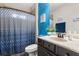 Bathroom showcasing stylish blue accents, marble countertops, and a shower with patterned curtains at 19313 Pummelo Dr, Orlando, FL 32827