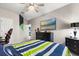 Bedroom featuring a television, black dresser, ceiling fan, and comfortable gaming chair at 19313 Pummelo Dr, Orlando, FL 32827