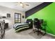 Bedroom with a unique green and black accent wall, complimented with a ceiling fan, and a desk space at 19313 Pummelo Dr, Orlando, FL 32827