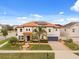 Elegant home exterior showcasing the two-story facade, blue front door, tile roof, and lush landscaping at 19313 Pummelo Dr, Orlando, FL 32827