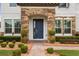 Inviting home entrance featuring a blue front door, stone pillars, and manicured landscaping at 19313 Pummelo Dr, Orlando, FL 32827