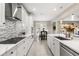 Gourmet kitchen with stainless steel appliances, white cabinetry, and mosaic backsplash at 19313 Pummelo Dr, Orlando, FL 32827