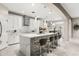 Open concept kitchen with white cabinets, large island, and modern bar stools, adjacent to dining area at 19313 Pummelo Dr, Orlando, FL 32827