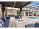 The outdoor living area features a fireplace, plush seating, a grill, and views of the pool at 19313 Pummelo Dr, Orlando, FL 32827