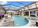 The screened-in pool features a spa, waterfall, and fire feature with an adjacent outdoor kitchen at 19313 Pummelo Dr, Orlando, FL 32827