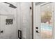 Modern walk-in shower with white marble tile and black hardware, with pool view at 19313 Pummelo Dr, Orlando, FL 32827