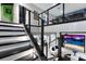 Stylish staircase with black and white treads, stainless steel cable railings, and modern lighting at 19313 Pummelo Dr, Orlando, FL 32827