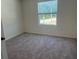 This is a bedroom with gray carpet and a window with a street view at 2005 Canton Park Dr, Winter Haven, FL 33881