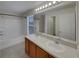 Bright bathroom with dual sinks, large mirror, and combined tub and shower at 2129 Betsy Ross Ln, St Cloud, FL 34769