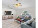 Cozy living room with a large window, wood-style flooring, plush seating, and a ceiling fan at 2540 Courtland Blvd, Deltona, FL 32738