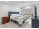 Main bedroom with wood-look floors, tufted headboard, a ceiling fan, and natural light through a window at 2540 Courtland Blvd, Deltona, FL 32738