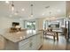 Kitchen island with seating overlooks the dining and living areas, enhancing the home's open concept design at 2721 Serenity Meadow Dr, Kissimmee, FL 34744