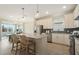 Bright kitchen features an island with seating, granite countertops, stainless steel appliances, and pendant lighting at 2721 Serenity Meadow Dr, Kissimmee, FL 34744