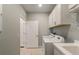 Well-lit laundry room with modern appliances, storage cabinets, and sink at 2721 Serenity Meadow Dr, Kissimmee, FL 34744
