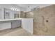 A tiled shower with gray vanity and mirror in this well lit bathroom at 2940 Scarlett Dr, St Cloud, FL 34772
