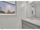Clean bathroom featuring a modern sink with sleek fixtures, a mirror, and a large window offering natural light at 2940 Scarlett Dr, St Cloud, FL 34772