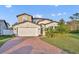 Inviting two-story home with a manicured lawn, brick driveway, and attached two-car garage at 2940 Scarlett Dr, St Cloud, FL 34772