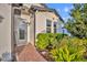 Charming home entrance with a decorative glass door, brick pathway, and lush landscaping at 2940 Scarlett Dr, St Cloud, FL 34772