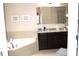 Elegant bathroom with a large tub, granite countertop vanity, and a built-in mirror at 3039 Boating Blvd. Blvd, Kissimmee, FL 34746